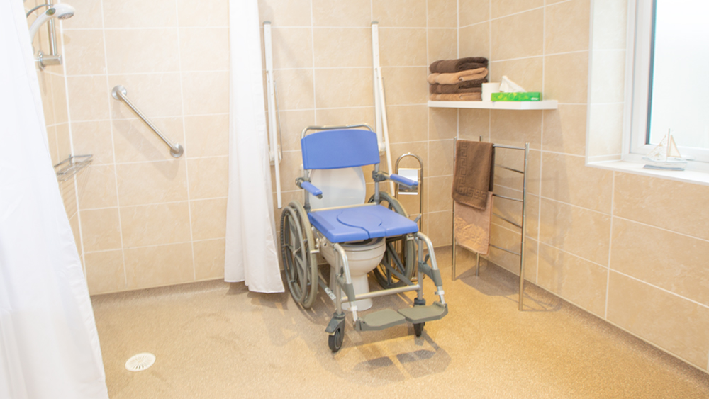 fully accessible wet room with choice of wheeled shower chairs available