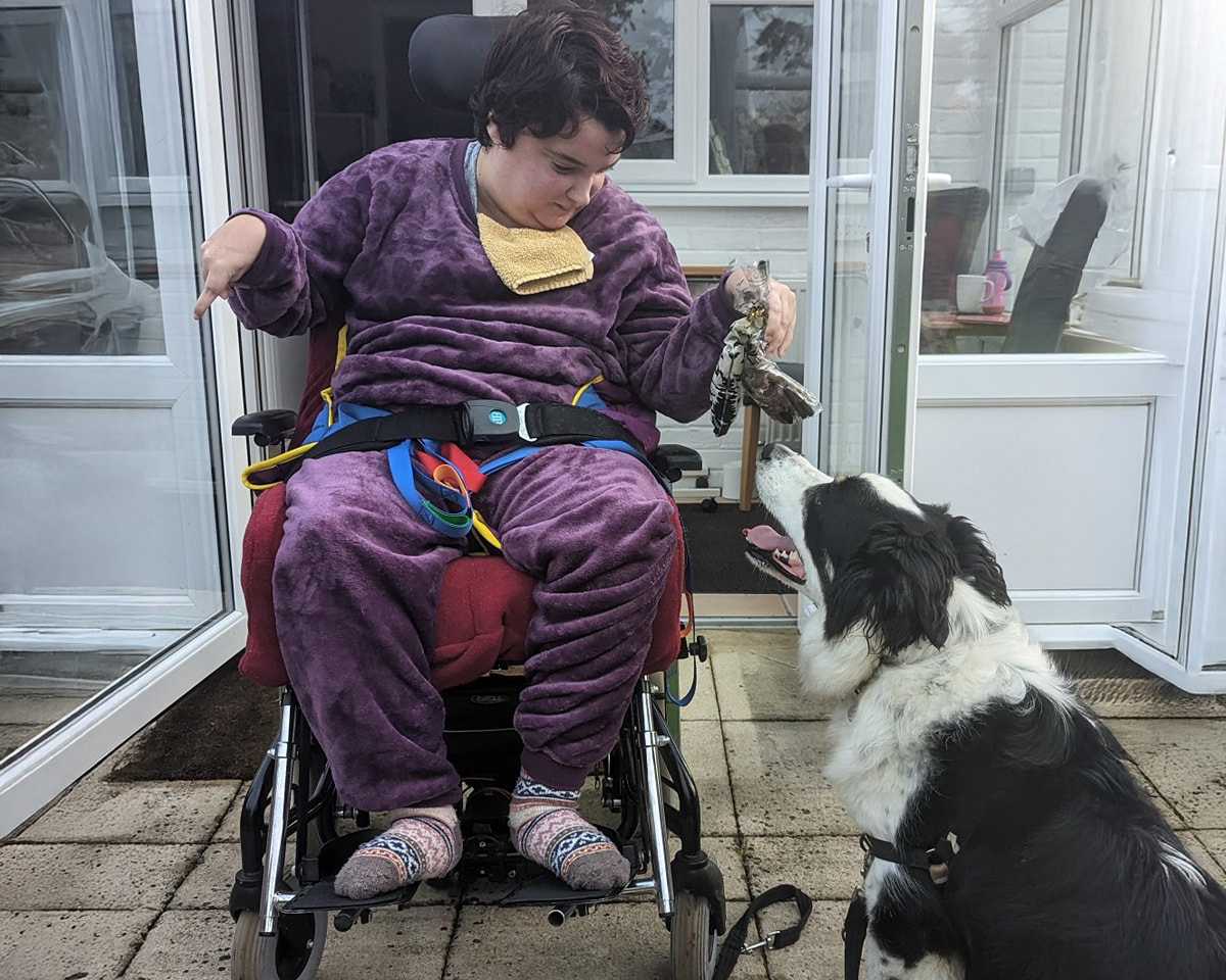 Disabled guest playing with a dog at an accessible cottage