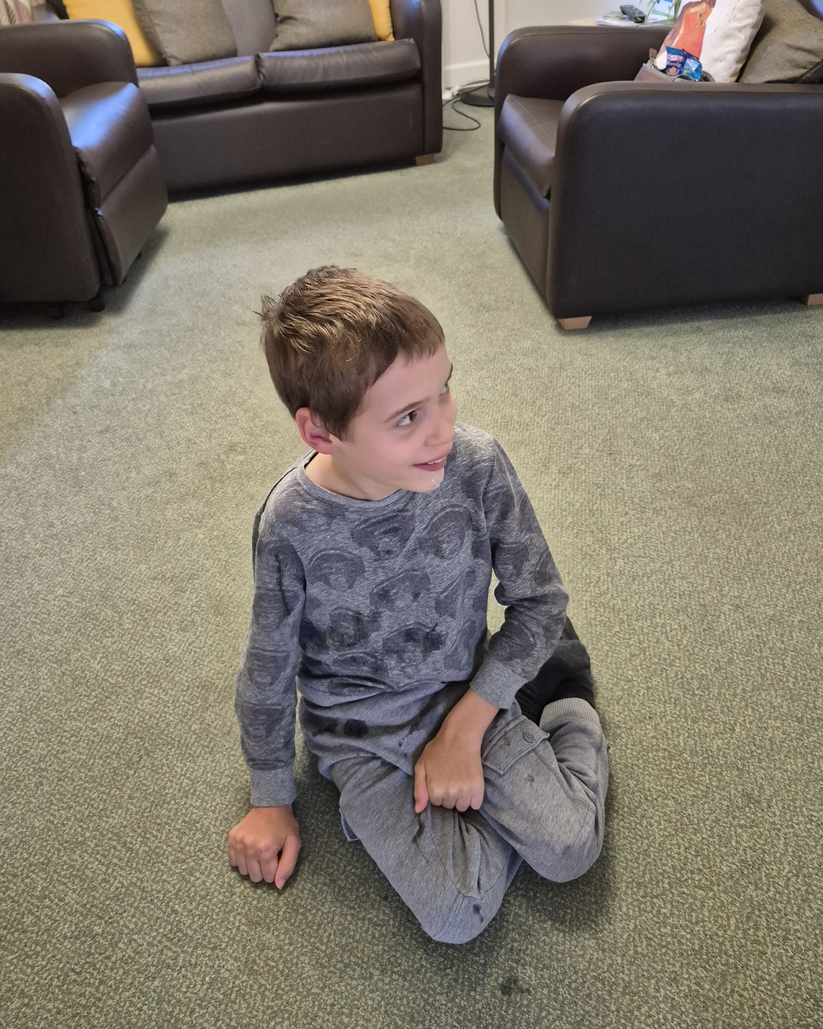 Finlay sitting in the spacious, level-access living room at Bench Cottage